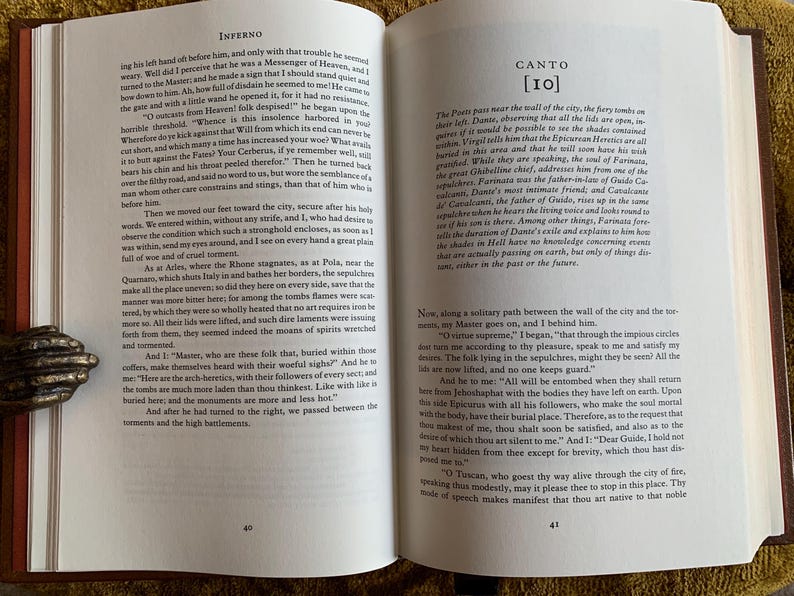 May include: An open book with a brown leather cover. The pages are open to Canto 10 of Inferno by Dante Alighieri. The text is in black and white and the page numbers are 40 and 41.