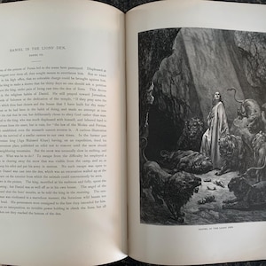 May include: A black and white illustration of a man standing in a cave with lions surrounding him. The man is wearing a long robe and has his hands raised in prayer. The text "DANIEL IN THE LIONS' DEN" is at the bottom of the image.
