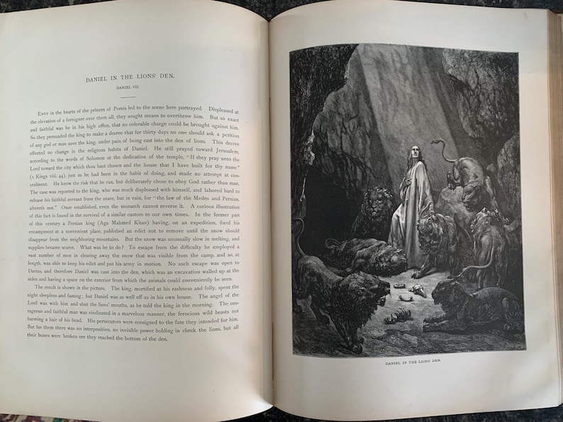 May include: A black and white illustration of a man standing in a cave with lions surrounding him. The man is wearing a long robe and has his hands raised in prayer. The text "DANIEL IN THE LIONS' DEN" is at the bottom of the image.