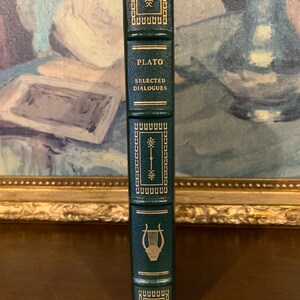 May include: A dark green hardcover book with gold lettering and a gold lyre design on the spine. The title of the book is "PLATO SELECTED DIALOGUES".