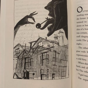 May include: A black and white ink illustration on a book page depicting a large, shadowy creature with an open mouth and a long tongue holding a key. Above a house, a large hand reaches down, scattering particles toward the building below.