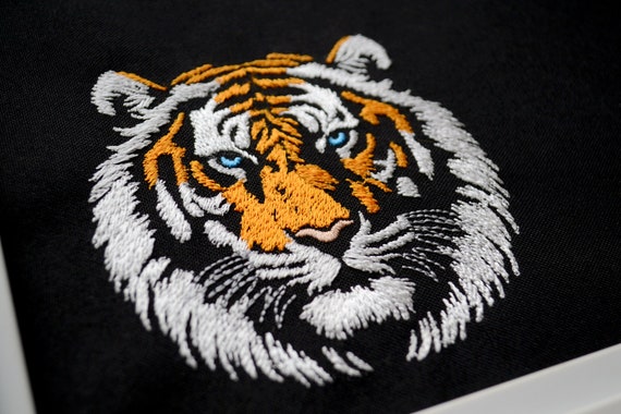 表情豊かな虎の頭の刺繍デザインセット - 黒の生地のジャングルキング