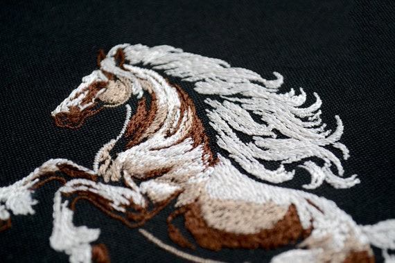 高貴な馬の刺繍デザイン - 濃い色の生地に白いたてがみを持つ野生の
