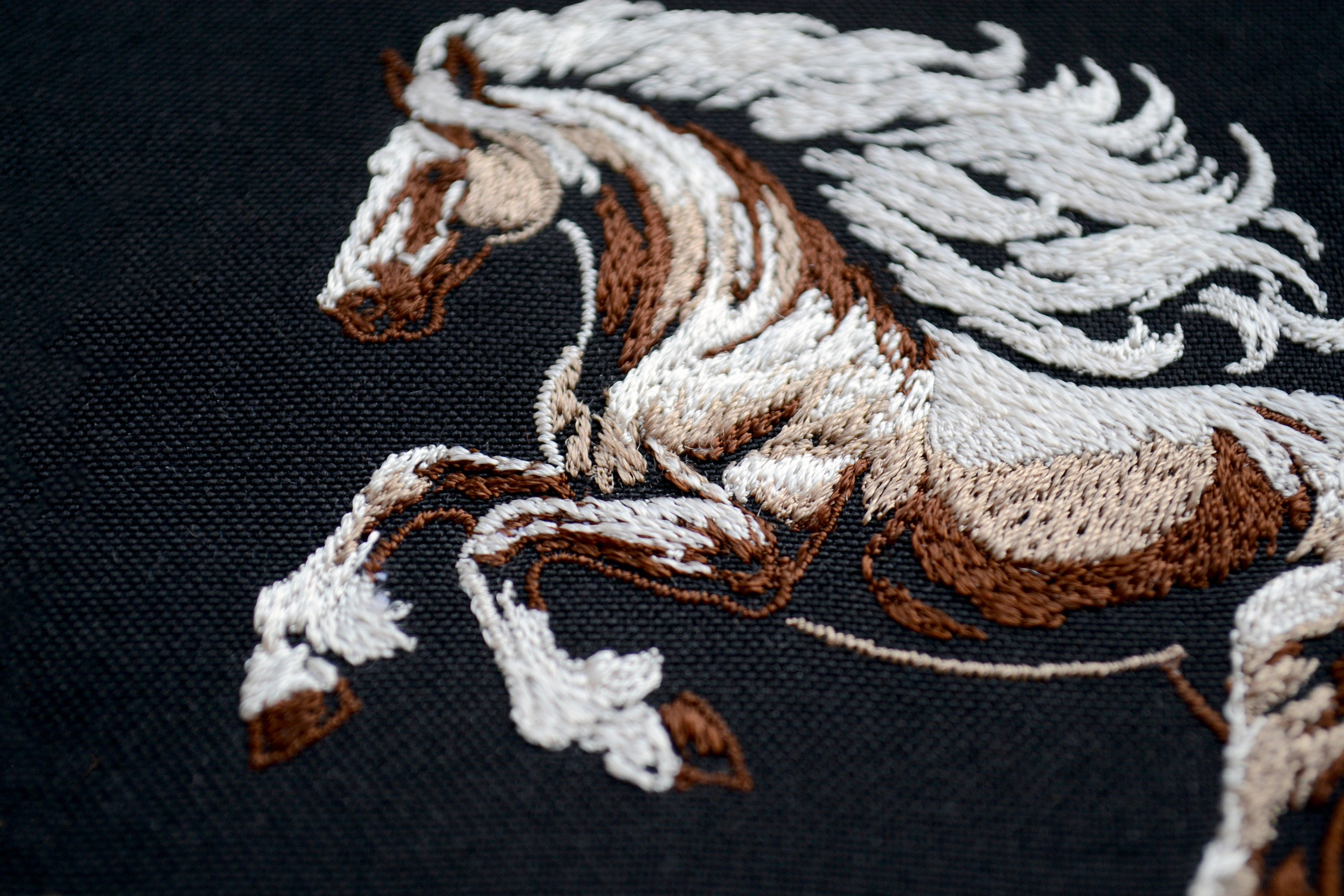 高貴な馬の刺繍デザイン - 濃い色の生地に白いたてがみを持つ野生の