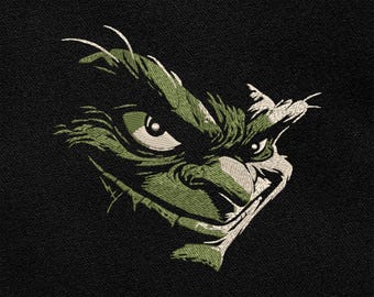 May include: Embroidered design of a green creature's face with a sinister grin and piercing eyes, set against a black background. The design features detailed stitching and a textured appearance, creating a striking contrast.