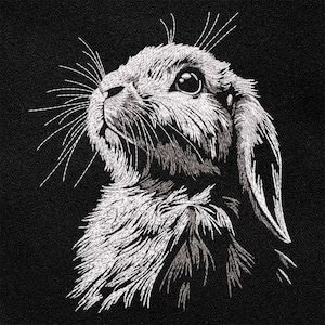 May include: A black and white embroidered image of a rabbit looking up with its ears perked up.