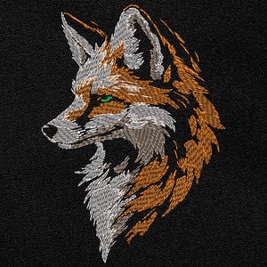 May include: Embroidered fox head profile in orange, white, and gray thread on a black background. The fox has green eyes and detailed stitching, creating a textured, artistic design. The image showcases a detailed animal portrait.