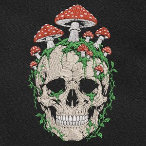 May include: An embroidered design on a black fabric background featuring a beige human skull covered in green vines and multiple red mushrooms with white spots. The mushrooms vary in size and are clustered around the top of the skull.