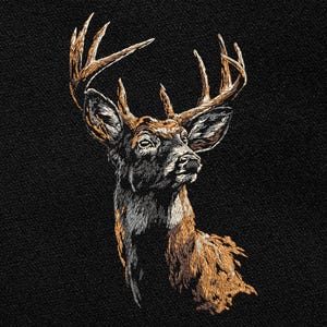 Puede incluir: Imagen bordada de la cabeza y los hombros de un ciervo, con cuernos y pelaje marrones detallados. La cara del ciervo es una mezcla de marrón, negro y blanco, sobre un fondo negro. La obra de arte muestra una representación realista del animal.