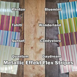 Puede incluir: Bandas flexibles con efecto metálico en varios colores, incluyendo azul, verde, amarillo, rosa y morado. Las bandas están dispuestas en un patrón vertical. Los nombres de los colores están escritos debajo de cada banda. El texto "Metallic Effekt Flex Stripes" está escrito en la parte inferior de la imagen.