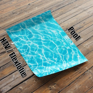 Puede incluir: Una lámina de vinilo termoadhesivo azul con un patrón de ondas de agua. El vinilo está etiquetado como "Pool" y "HTV / Flexfolie".