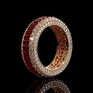 May include: A gold eternity ring featuring a central row of rectangular-cut deep red rubies flanked by two rows of small, round, clear white diamonds. The inner band of the ring displays a repeating cutout pattern of circular coin-like shapes.