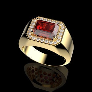 Könnte beinhalten: Ein goldener Ring mit einem großen, rechteckigen, tiefroten Edelstein, umgeben von kleineren, klaren Edelsteinen. Der Ring hat einen dicken Schaft und eine polierte Oberfläche, vor schwarzem Hintergrund.