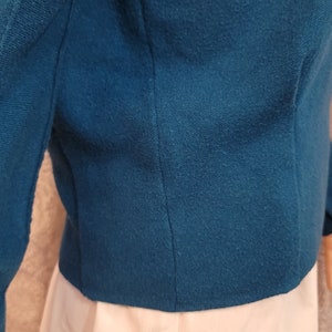 Pu&ograve; includere: Un blazer blu teal a maniche lunghe e chiusura con un solo bottone. Il blazer &egrave; realizzato in un tessuto morbido e testurizzato.