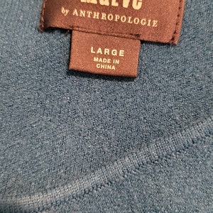 Pu&ograve; includere: Un'etichetta marrone scuro con testo bianco che recita "Maeve by Anthropologie" e "Large Made in China".