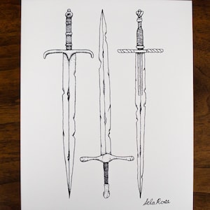 May include: A black and white ink illustration on white paper featuring three distinct swords with detailed hilts and weathered, notched blades. The artwork is signed Sela Rose in the bottom right corner, showcasing intricate line work and shading.
