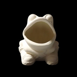 May include: White ceramic frog planter with a large open mouth, perfect for holding small plants or succulents. The frog is sitting with its legs crossed and has a wide, toothy grin.