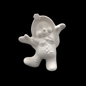 Puede incluir: Figura de cerámica blanca de un muñeco de nieve con los brazos extendidos, que lleva un sombrero con un diseño de copo de nieve. El muñeco de nieve tiene una cara redonda con una nariz de botón y una sonrisa.