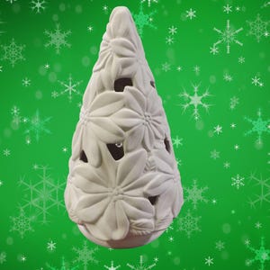 Op de afbeelding: Een witte keramische kerstboomvormige kandelaar. De boom is versierd met grote, gestileerde bloemvormen en heeft openingen waardoor het licht kan schijnen. De basis is lichtroze.