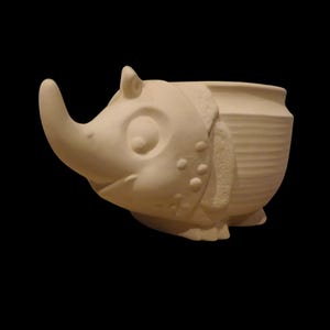 May include: White ceramic planter shaped like an armadillo with a textured shell and a large snout.