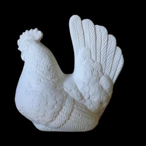 Könnte beinhalten: Eine weiße Keramik-Hahnfigur mit detaillierten Feder- und Kammstrukturen. Der Hahn ist mit gedrehtem Kopf und aufgefächerten Schwanzfedern vor schwarzem Hintergrund dargestellt. Ein dekoratives Bauernhoftier.