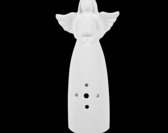 Może przedstawiać: Biała ceramiczna figurka anioła z rozłożonymi skrzydłami i powłóczystą szatą. Anioł ma spokojny wyraz twarzy i małe okrągłe wycięcia z przodu. Tło jest jednolicie czarne.