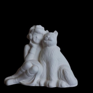 Könnte beinhalten: Eine weiße Keramikfigur, die eine sitzende Person mit einer Katze darstellt. Die Person stützt den Kopf auf die Hand, die Katze sitzt aufrecht daneben. Die Figur ist unbemalt und hat eine glatte Oberfläche.