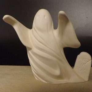 May include: White ceramic ghost figurine with a flowing robe and a tombstone that reads "Rest in Peace".