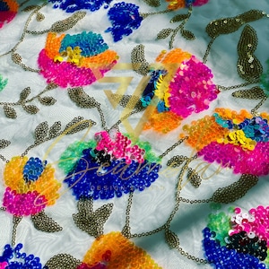 May include: White mesh fabric with colorful sequins in the shape of flowers. The sequins are in shades of pink, blue, green, yellow, and orange.