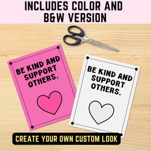 May include: Two rectangular cards with black dashed borders and the text BE KIND AND SUPPORT OTHERS. One card has a pink background with a pink heart, and the other is white with a black heart outline. A pair of black scissors is positioned above.