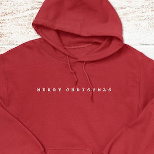 May include: Red hooded sweatshirt with the text "Merry Christmas" in white on the front.
