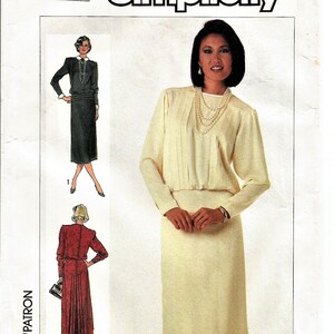 May include: Simplicity sewing pattern featuring a woman in a cream-colored dress with long sleeves and a pleated bodice. The pattern includes illustrations of other dress designs. The pattern size is 10, with a European size of 38.