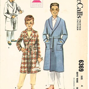 May include: A vintage sewing pattern for a boy's robe. The pattern is for size 4 and is printed on a white background with a pink and black border. The pattern shows a boy wearing a blue robe with a white collar and a plaid robe with a white collar. The pattern is titled "McCall's Printed Pattern 6369 Boys' Robe".