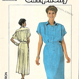 May include: Simplicity sewing pattern featuring a blue button-down dress and a cream-colored dress. The pattern number is 7942, with size K (8+10+12) and EUR K (36+38+40). The Simplicity logo is displayed at the top.