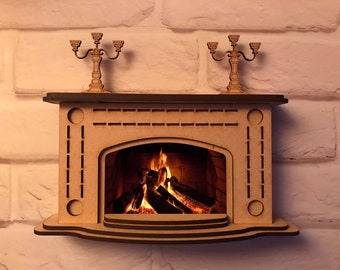 Puede incluir: Un modelo de madera de una chimenea con un fuego realista ardiendo en su interior. La chimenea tiene una repisa con dos candelabros a cada lado. La chimenea está pintada de color marrón claro.