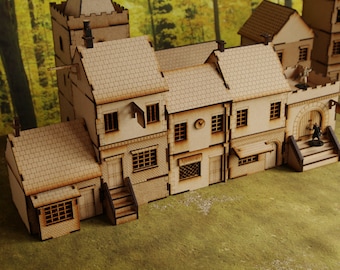 Könnte beinhalten: Ein Holzmodell eines mittelalterlichen Dorfes mit einer Kirche, einem Laden und einem Haus. Die Gebäude sind aus hellbraunem Holz gefertigt und haben detaillierte Fenster und Türen. Das Modell steht auf einer grünen Grasfläche.