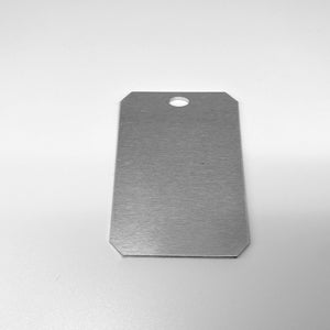 May include: A silver metal tag with a rounded rectangular shape and a hole punched in the top.