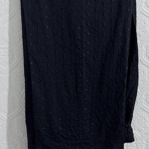 May include: Black embroidered pants with a lace trim. The pants are made of a lightweight fabric and have a relaxed fit.