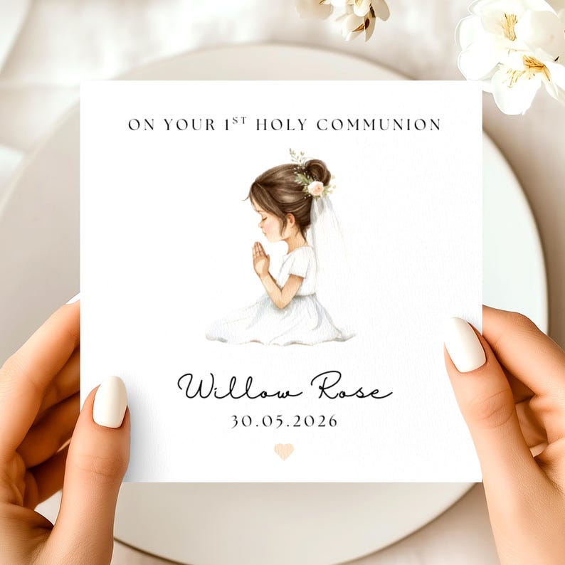 May include: A white card with the text "ON YOUR 1ST HOLY COMMUNION" and the name "Willow Rose" with the date "30.05.2026". The card features an illustration of a girl in a white dress with her hands clasped in prayer.