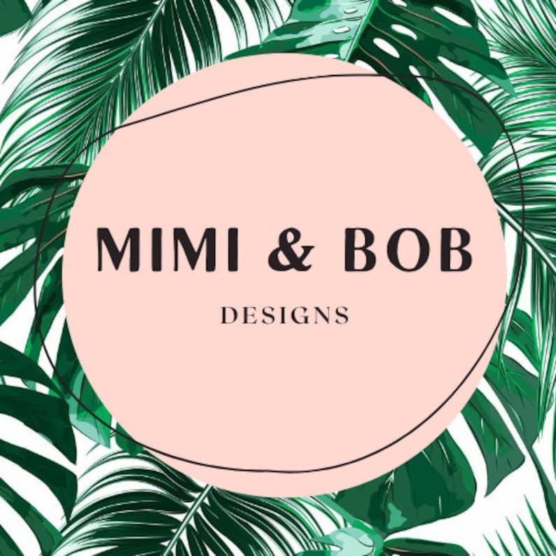 May include: A logo design featuring the text "MIMI & BOB DESIGNS" in a black font, set within a light pink circle. The circle is framed by a thin black line and surrounded by a background of lush green tropical leaves.