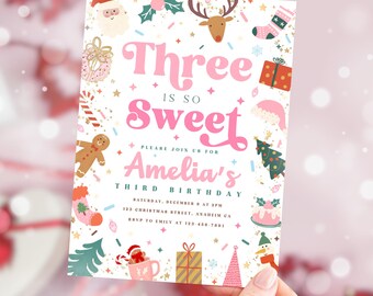 May include: A festive invitation for a third birthday party. The design features a pink and white color scheme with Christmas-themed illustrations, including a Santa, reindeer, and gingerbread man. The text reads "Three is so Sweet" and invites guests to Amelia's third birthday.