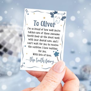 May include: A blue and white tooth fairy note with gold stars and the text "To Oliver I'm so proud of how well you're taking care of those awesome teeth! Keep up the great work with your dental care, and I can't wait for you to receive the surprise I have waiting for you. With lots of love, the tooth fairy"