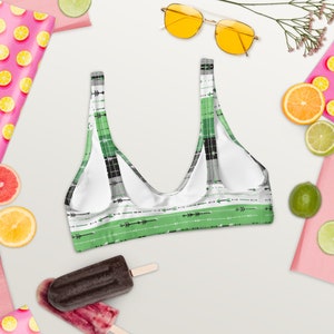 May include: Green and black patterned bikini top with a scoop neck and adjustable straps. The pattern features small arrows and stripes.