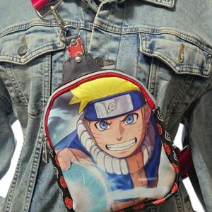 May include: A red and black crossbody bag with a Naruto character printed on the front. The bag has a zipper closure and a red adjustable strap.
