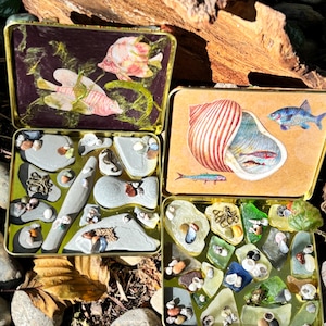 Shell, sea glass, beach stone,  and octopus, turtle and seahorse charms in a repurposed cigar tin.  Handmade, unique ocean, coastal art.