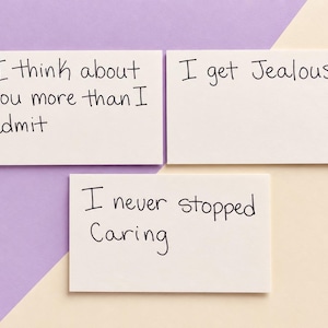 Puede incluir: Tres tarjetas rectangulares blancas con texto escrito a mano en negro. La primera tarjeta dice I think about you more than I admit. La segunda tarjeta dice I get Jealous. La tercera tarjeta dice I never stopped Caring. Las tarjetas están agrupadas.