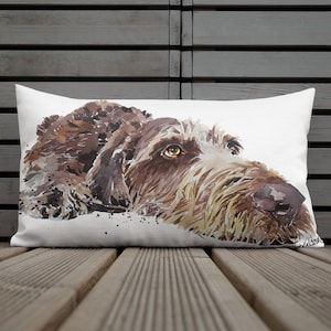 Könnte beinhalten: Ein Aquarellbild eines braunen und weißen Hundes vor weißem Hintergrund. Der Hund liegt mit dem Kopf zur Seite gedreht und schaut nach oben. Das Bild ist auf einem weißen Kissen.