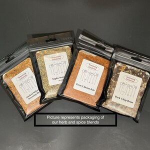Peut inclure: Quatre petits sachets refermables noirs remplis de diff&eacute;rents m&eacute;langes d'&eacute;pices. Les sachets sont &eacute;tiquet&eacute;s avec le texte "Seasoning Solutions" et les noms des m&eacute;langes : "Smoked Molasses Seasoning Blend", "Naples Seasoning", "Texas Chicken Rub" et "Pork Chop Brine".