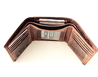 Puede incluir: Una cartera de cuero marrón con múltiples ranuras para tarjetas y un portafolios. La cartera está abierta y muestra el interior con dos tarjetas de crédito y una etiqueta que dice "SEDON Leather Portfolio USA".