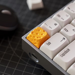Peut inclure: Gros plan sur un clavier avec un capuchon de touche jaune à surface texturée. Le capuchon de touche est étiqueté "tab".